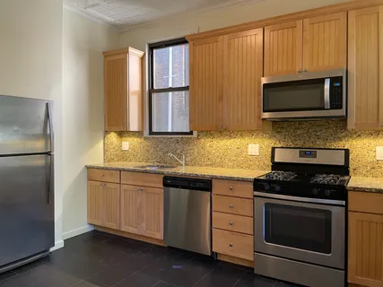 a kitchen with stainless steel appliances granite countertop a stove microwave and refrigerator
