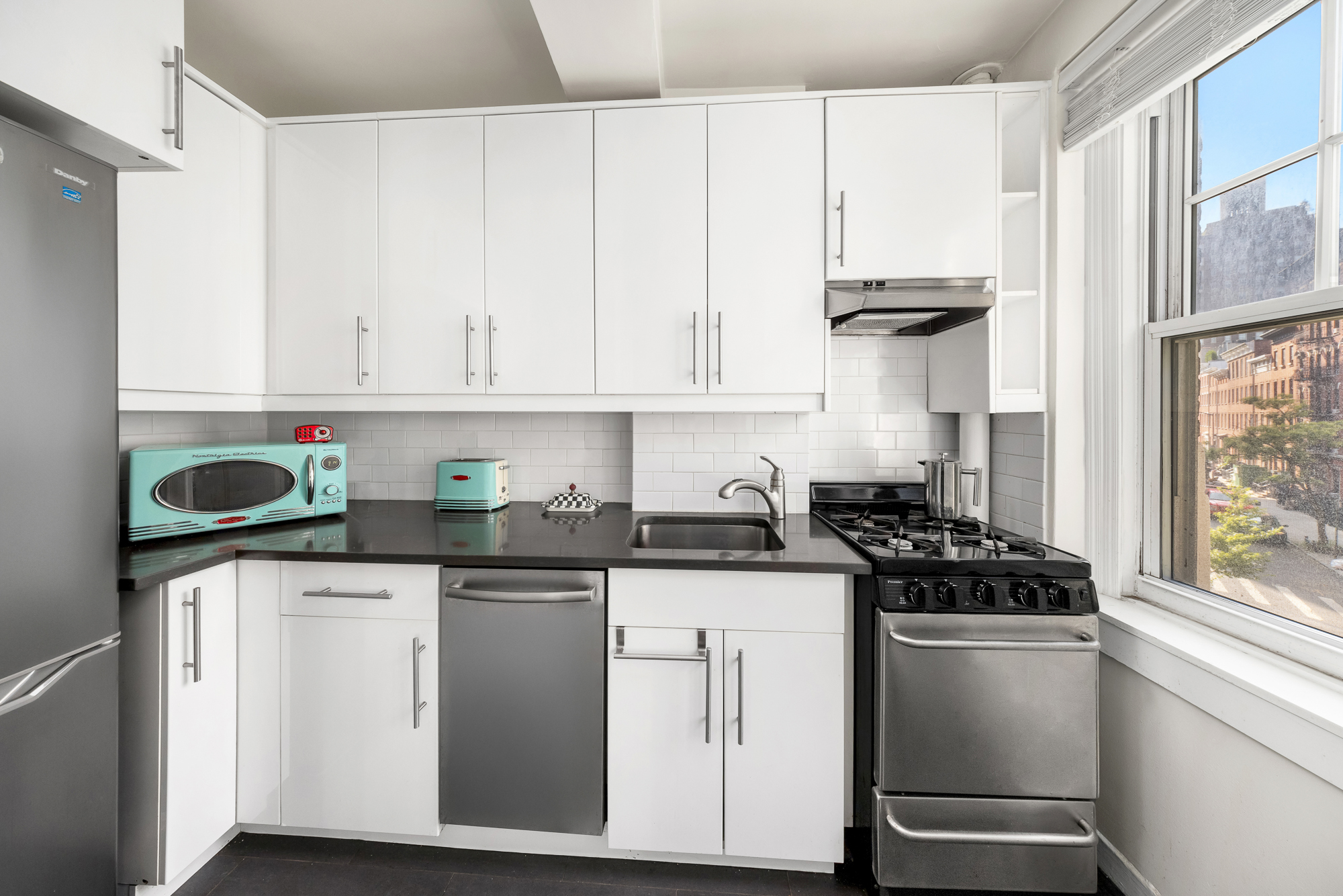 45 Christopher Street, Unit 3C Manhattan, NY 10014 - Photo 8 of 11 a kitchen with stainless steel appliances granite countertop a sink stove and cabinets