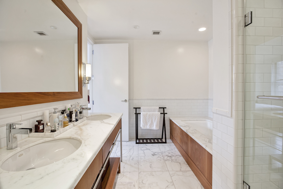 150 Nassau Street, Unit 19A Manhattan, NY 10038 - Photo 5 of 16 a bathroom with a double vanity sink and a bathtub