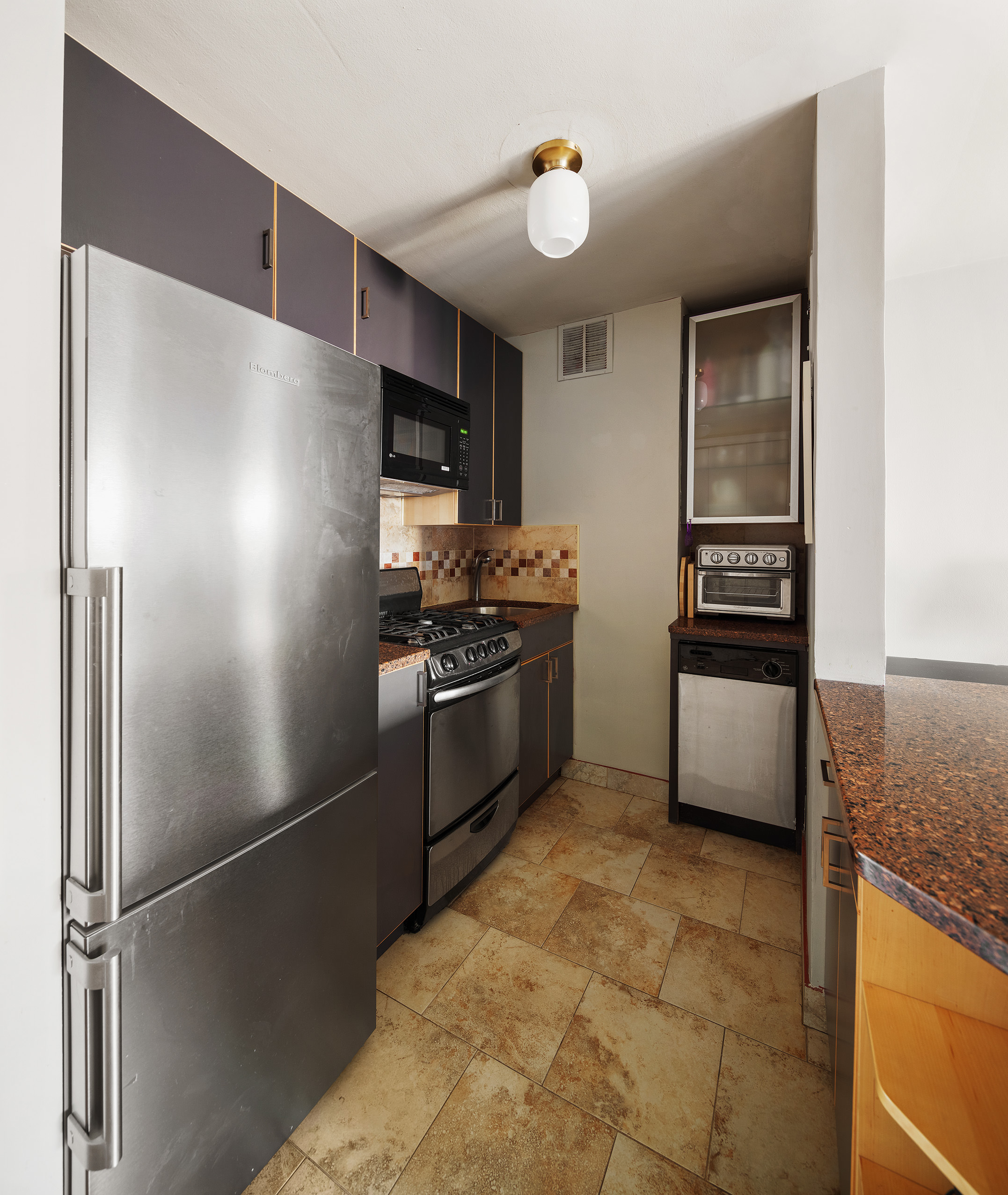245 East 24th Street, Unit 9B Manhattan, NY 10010 - Photo 5 of 7 a kitchen with stainless steel appliances granite countertop a refrigerator and a stove