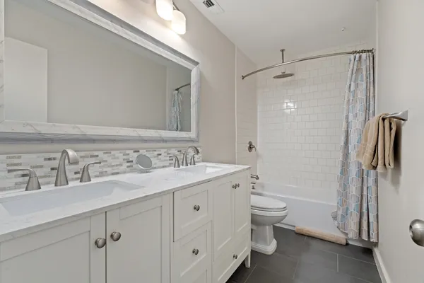 a view of a patio with a table and chairs and a barbeque