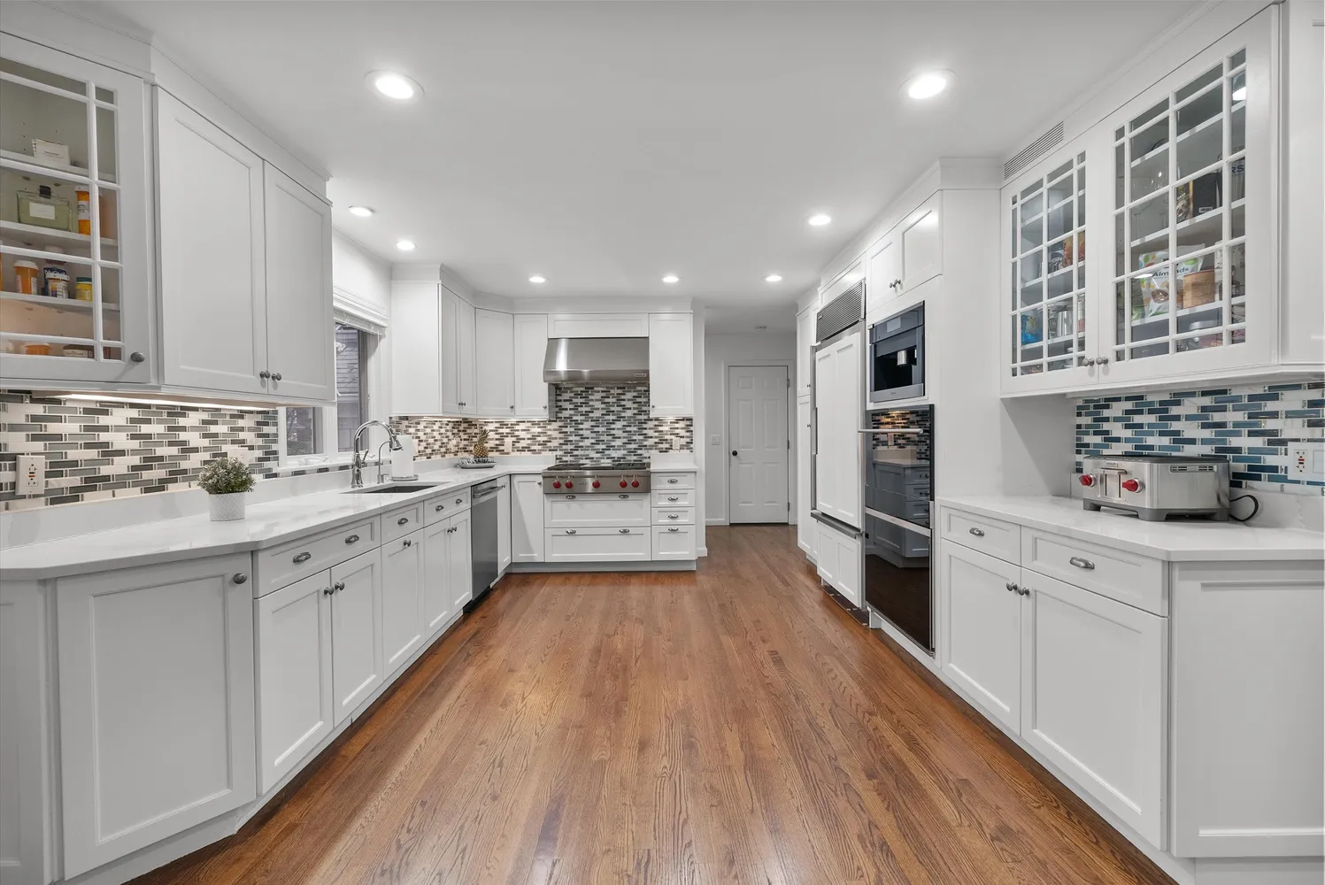 a large kitchen with stainless steel appliances kitchen island granite countertop a stove and a sink