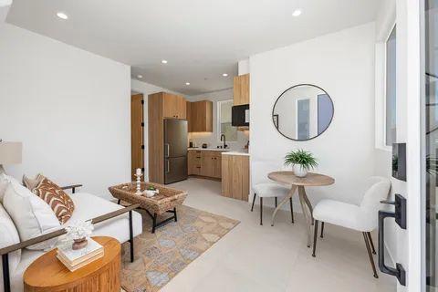 a living room with furniture a rug and white walls