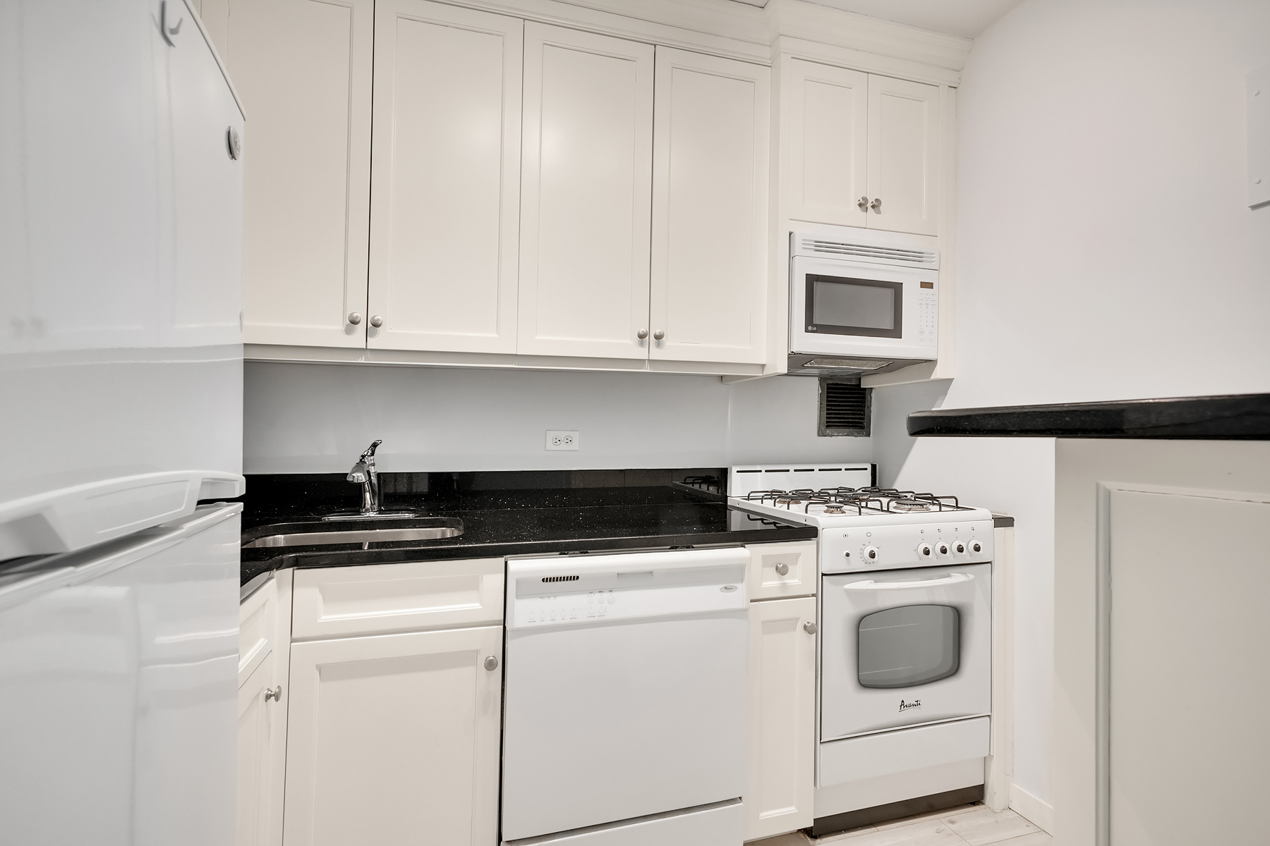 330 East 75th Street, Unit 3L Manhattan, NY 10021 - Photo 8 of 14 a kitchen with granite countertop white cabinets and white appliances