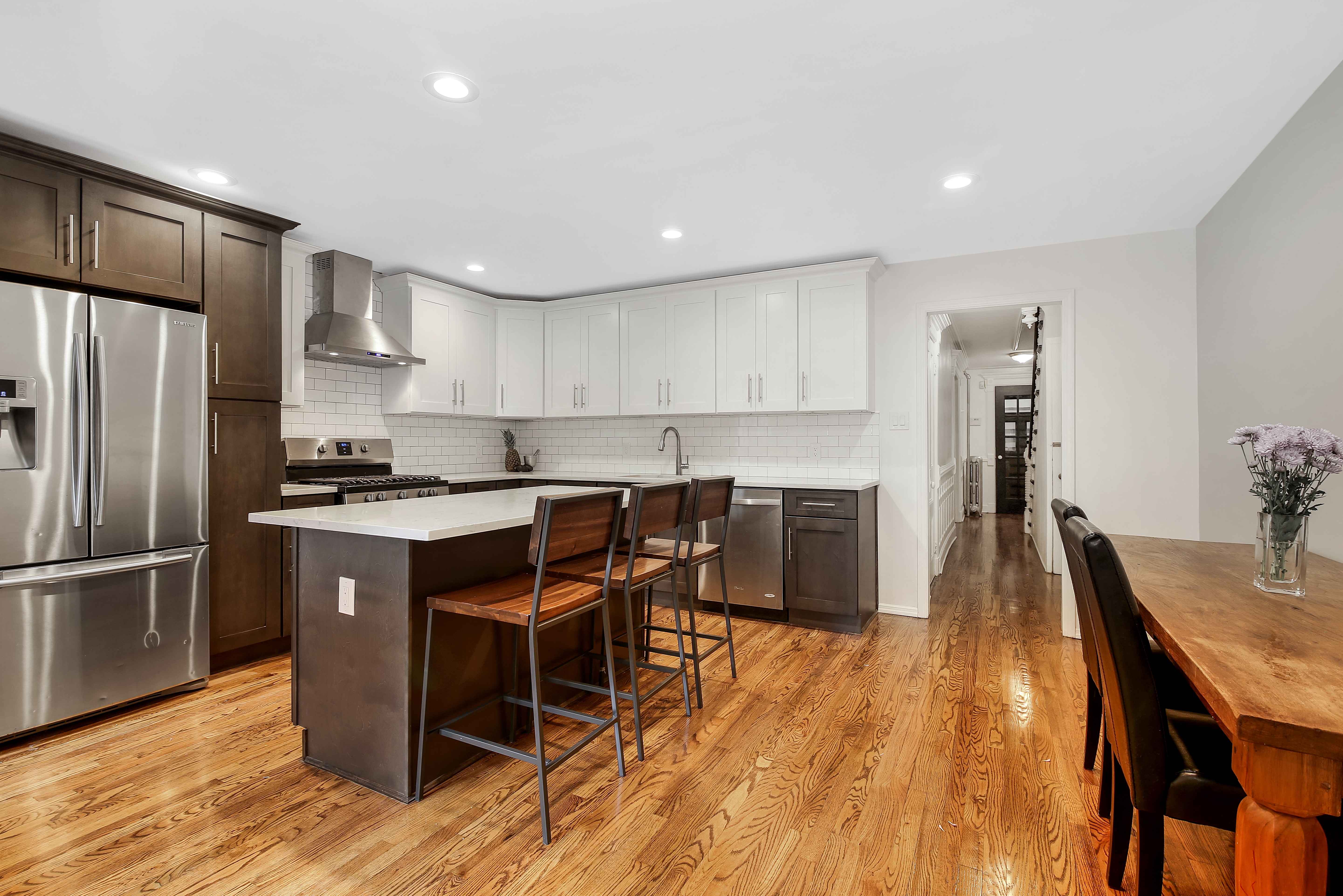666 Putnam Avenue, Unit 1 Brooklyn, NY 11221 - Photo 1 of 8 a kitchen with stainless steel appliances granite countertop a table chairs sink refrigerator and cabinets