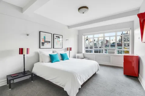 a bedroom with a bed and a large window