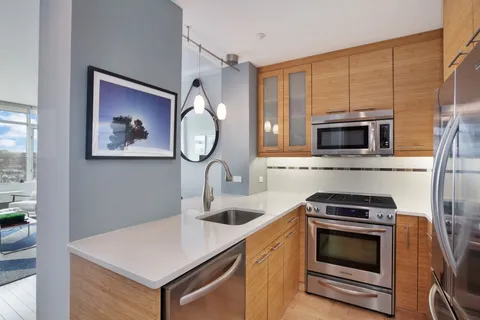a kitchen with stainless steel appliances a stove microwave and sink