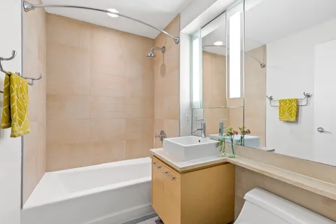 a bathroom with a granite countertop sink and a bathtub
