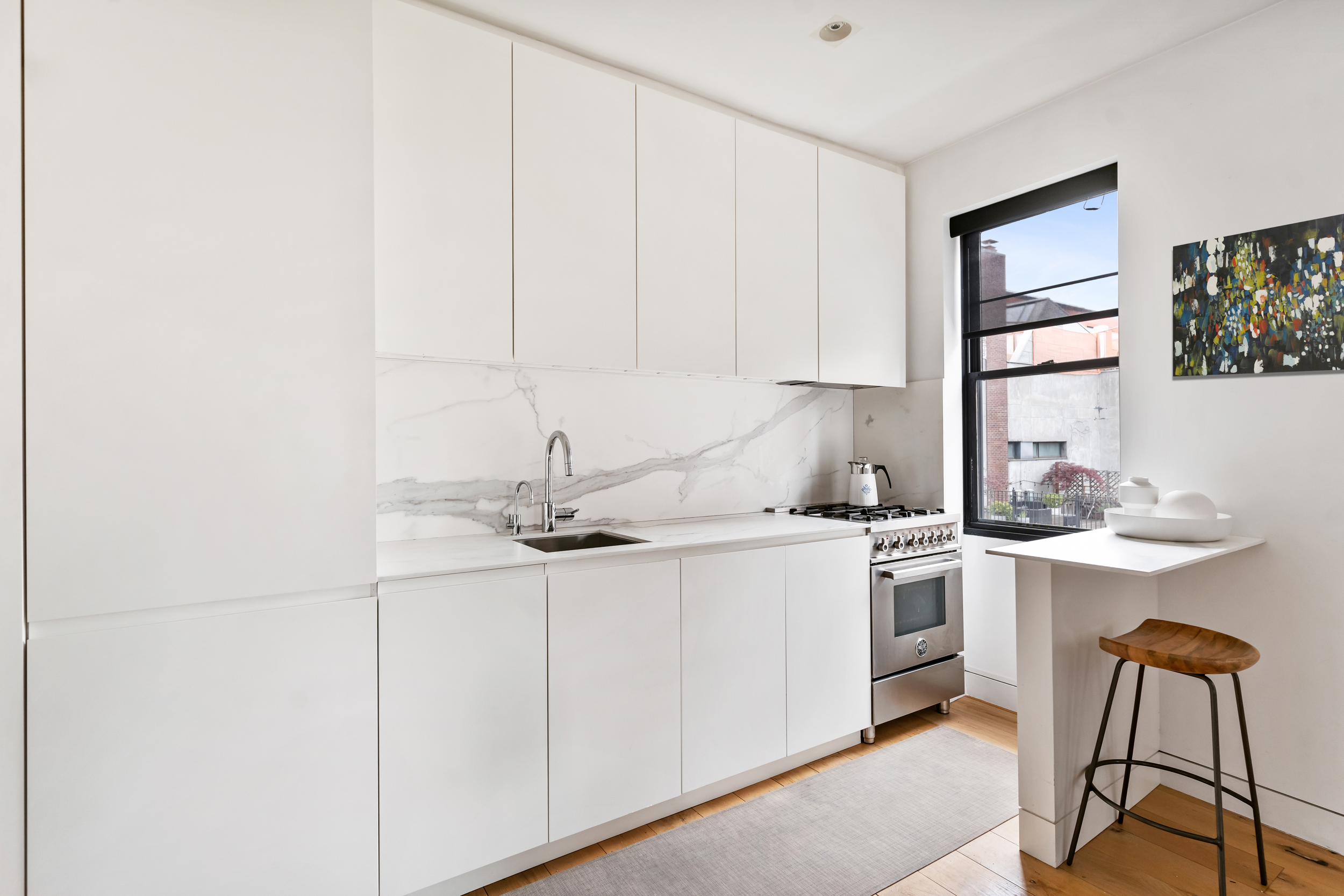 61 Horatio Street, Unit 5F Manhattan, NY 10014 - Photo 3 of 11 a kitchen with stainless steel appliances granite countertop a sink and cabinets