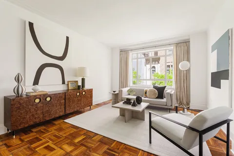 a living room with furniture a window and a lamp