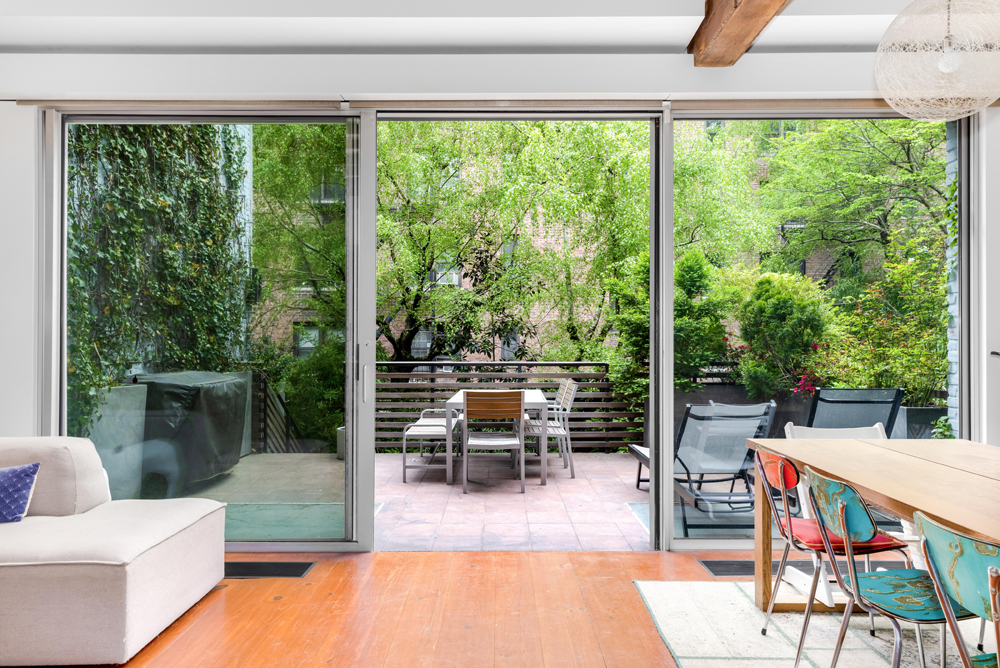 308 West 19th Street, Unit GARDEN Manhattan, NY 10011 - Photo 2 of 18 a living room with patio furniture and floor to ceiling windows
