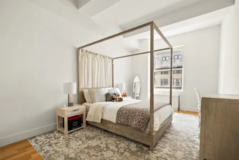 a bedroom with a bed table and a window
