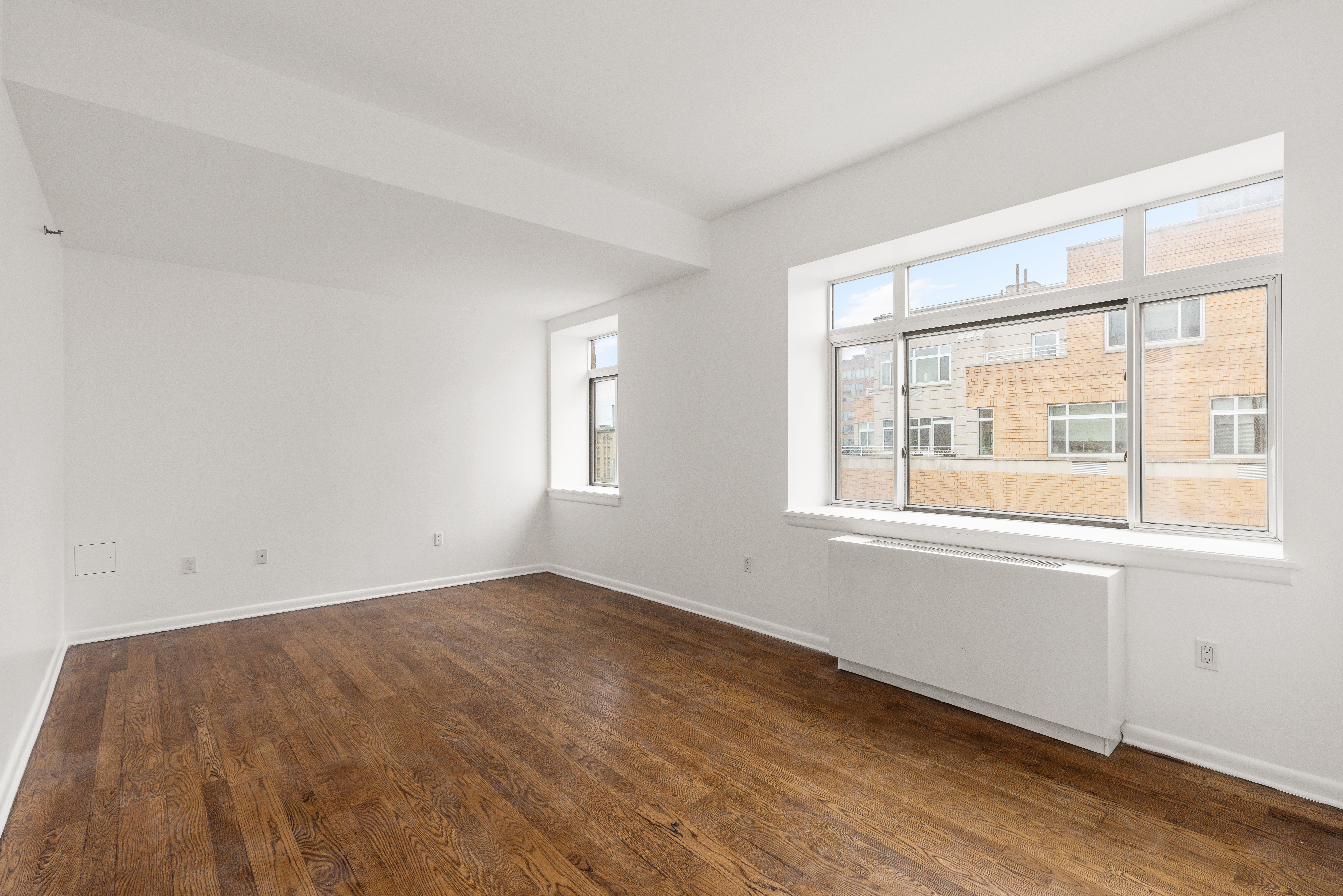 2279 3rd Avenue, Unit 6B Manhattan, NY 10035 - Photo 8 of 10 an empty room with wooden floor and windows