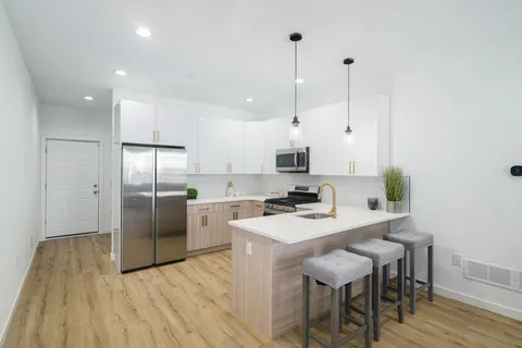 a kitchen with white cabinets stainless steel appliances and dining table