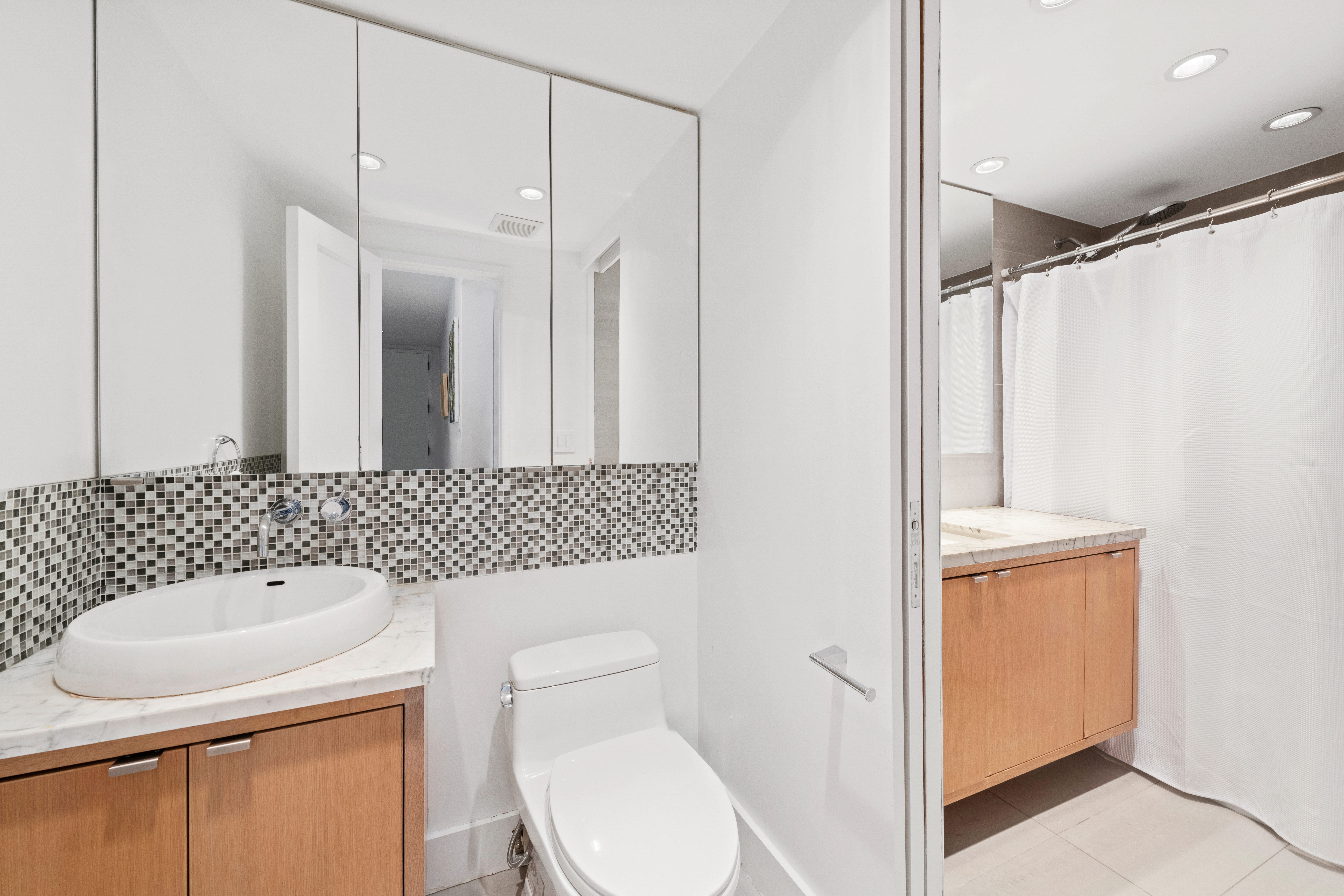 120 East 87th Street, Unit R16G Manhattan, NY 10128 - Photo 15 of 20 a bathroom with a toilet a sink and a mirror