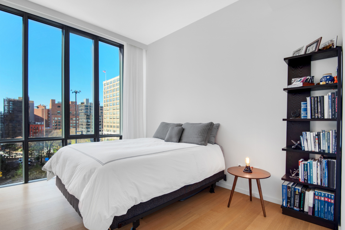 565 Broome Street, Unit S8C Manhattan, NY 10013 - Photo 15 of 24 a bedroom with a bed book shelf and a window