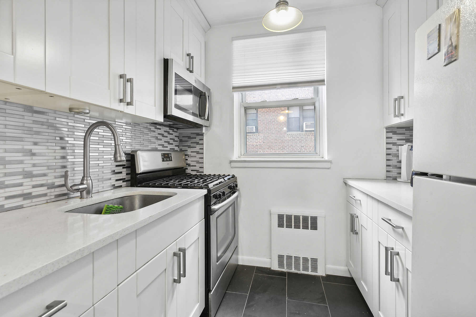 102-55 67th Drive, Unit 2C Queens, NY 11375 - Photo 3 of 6 a kitchen that has a sink and a stove