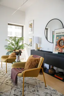 a living room with furniture and a mirror