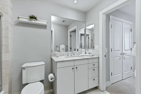 a bathroom with a toilet a sink and mirror