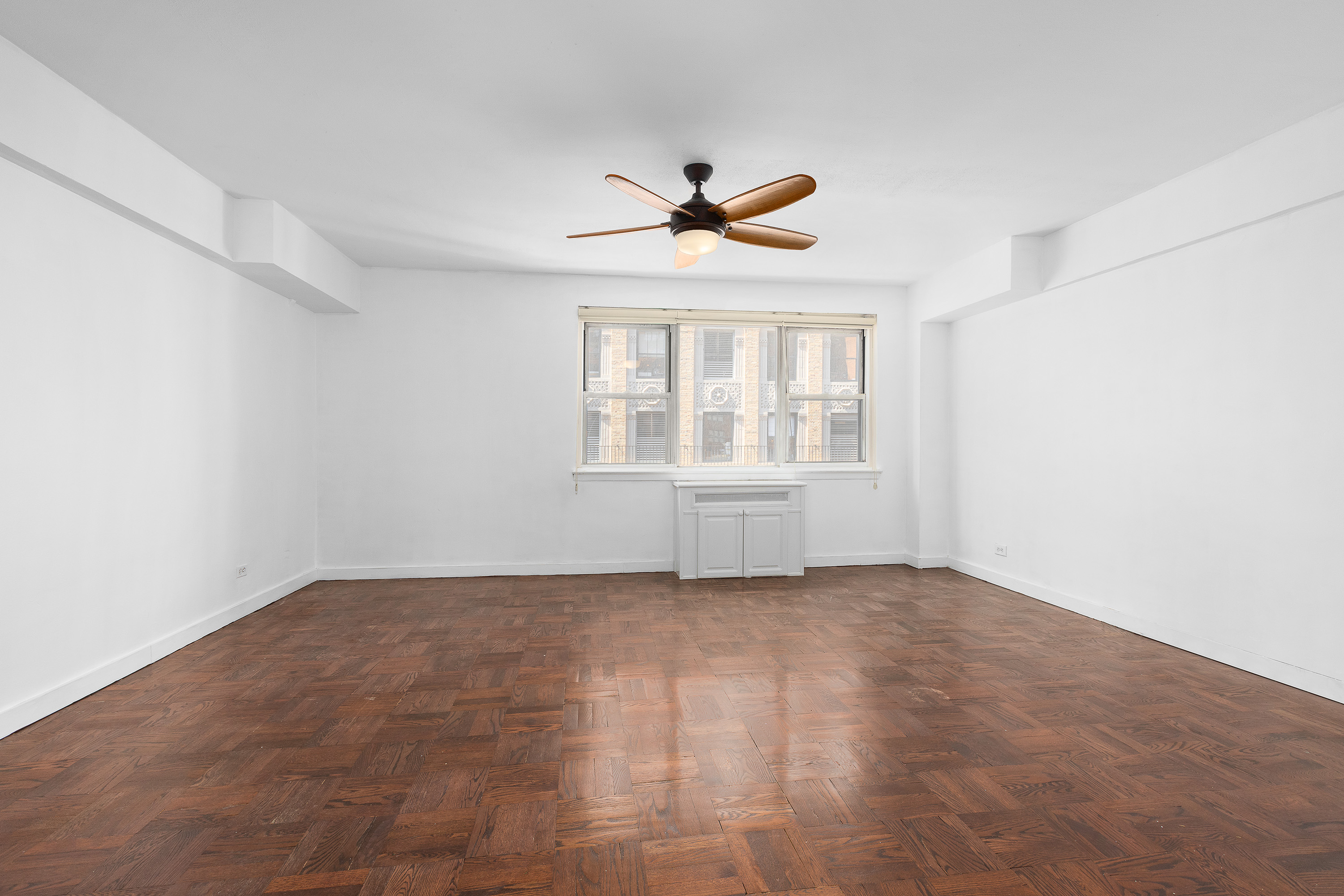 139 East 33rd Street, Unit 15G Manhattan, NY 10016 - Photo 4 of 11 an empty room with chandelier fan and windows