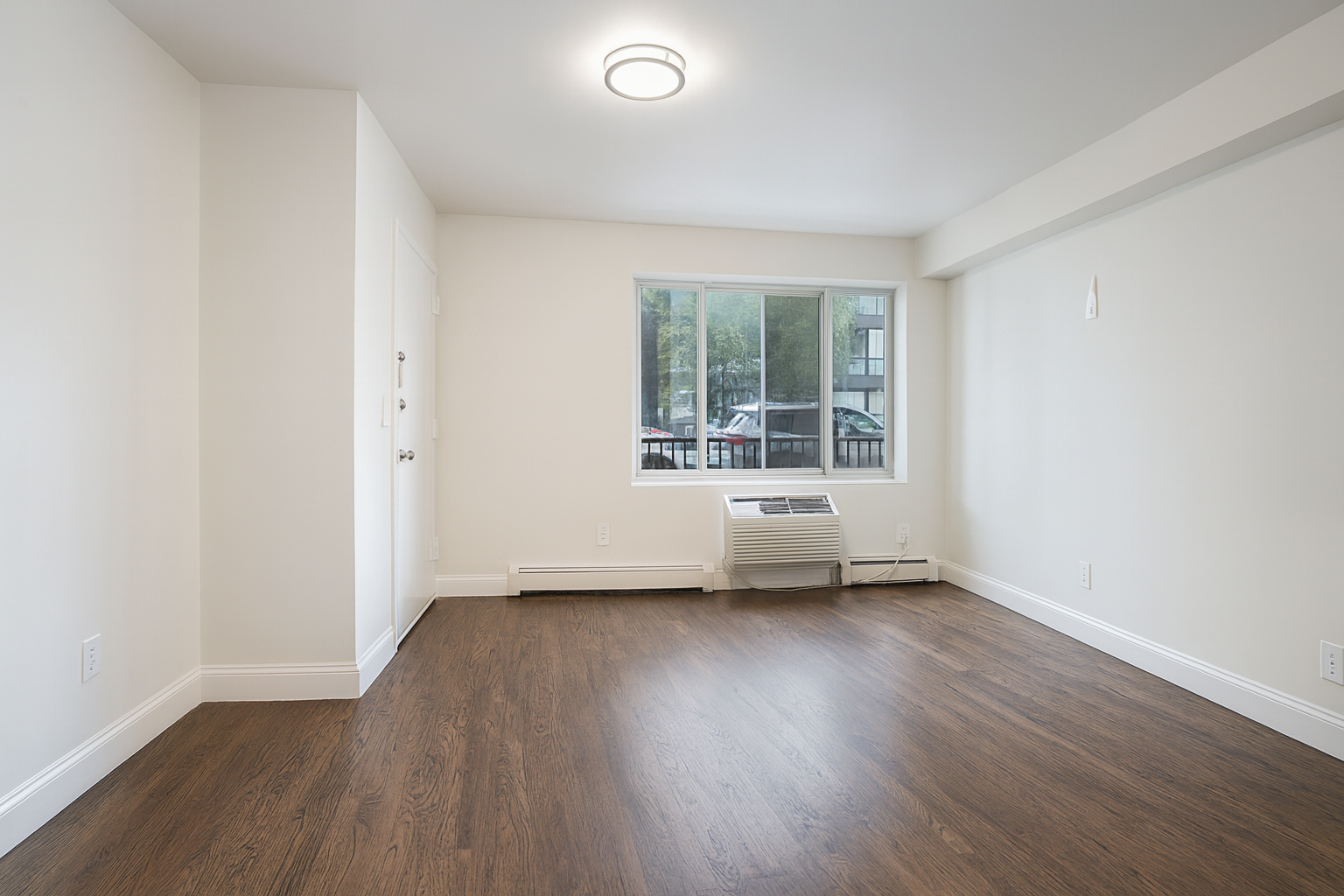 187 Woodpoint Road Brooklyn, NY 11211 - Photo 8 of 17 an empty room with wooden floor and windows