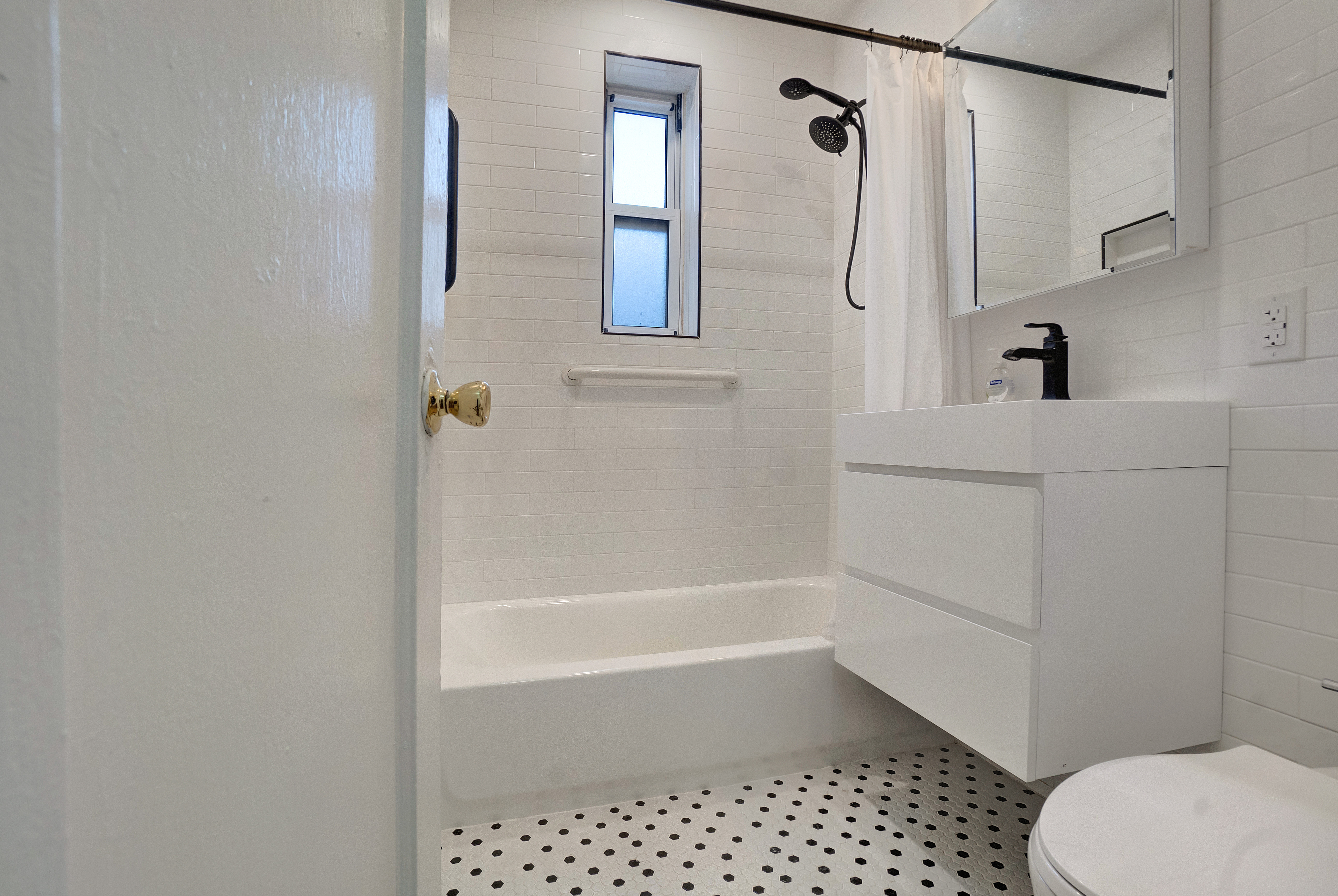 286 Corbin Place, Unit 2A Brooklyn, NY 11235 - Photo 5 of 13 a bathroom with a sink a toilet and shower
