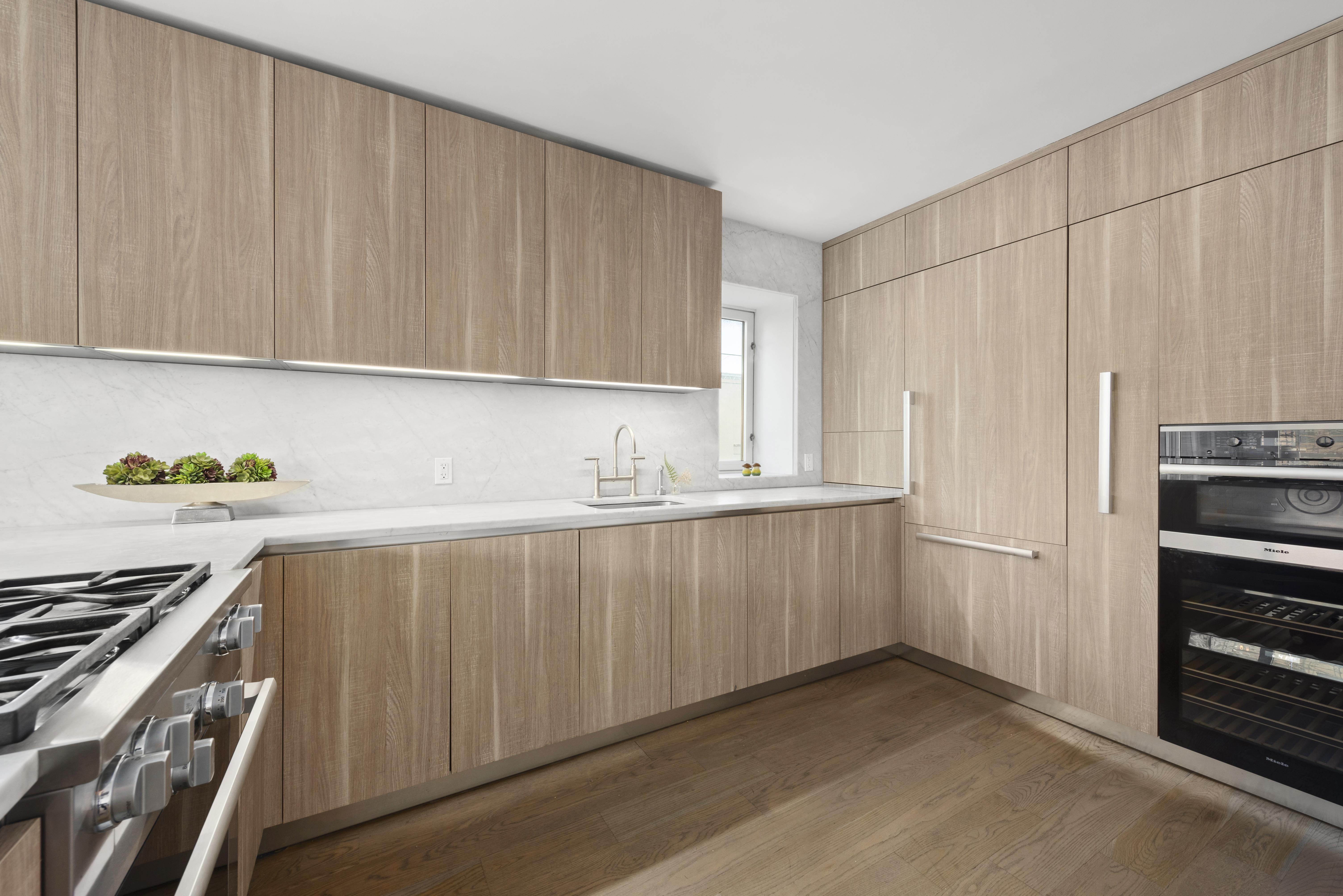 265 East Houston Street, Unit 4 Manhattan, NY 10002 - Photo 8 of 20 a kitchen with stainless steel appliances white cabinets and a stove top oven