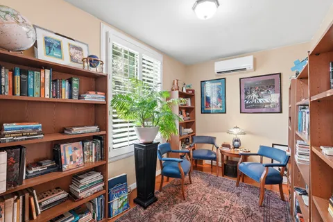 a living room with furniture and a book shelf