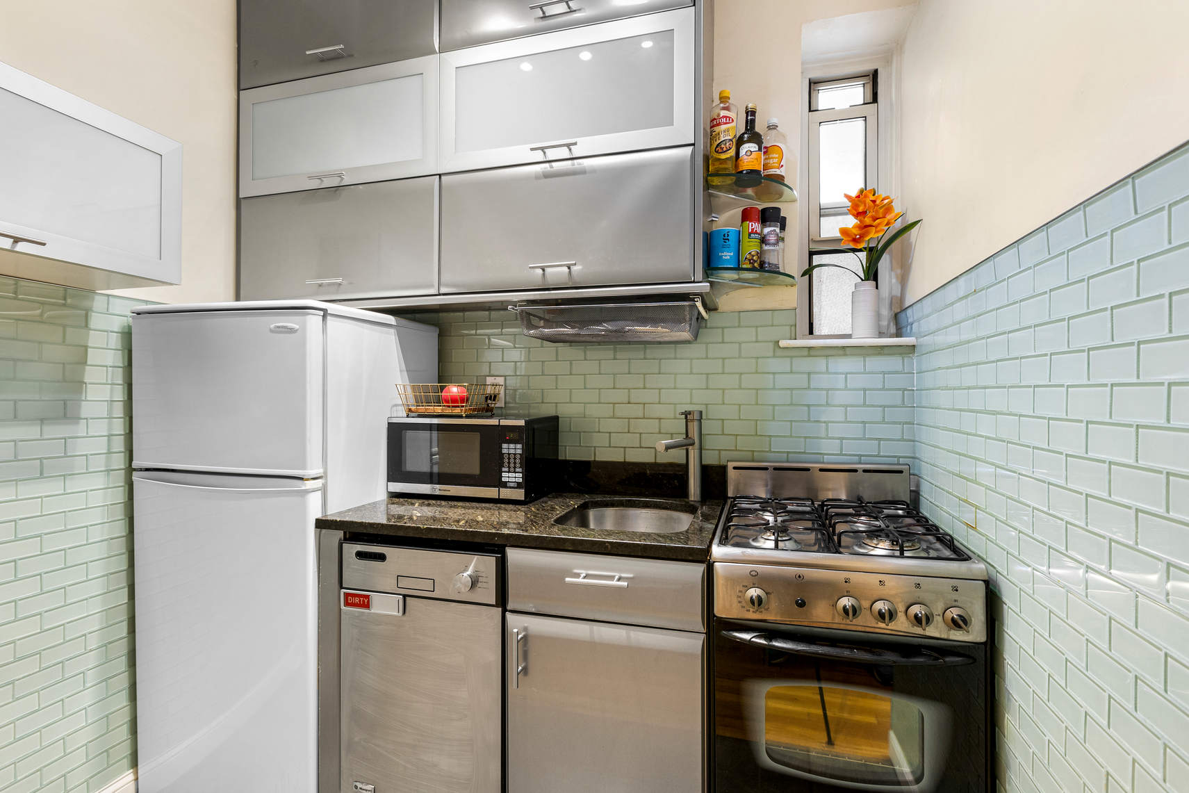 313 East 89th Street, Unit 4C Manhattan, NY 10128 - Photo 2 of 8 a kitchen with stainless steel appliances granite countertop a stove and a refrigerator