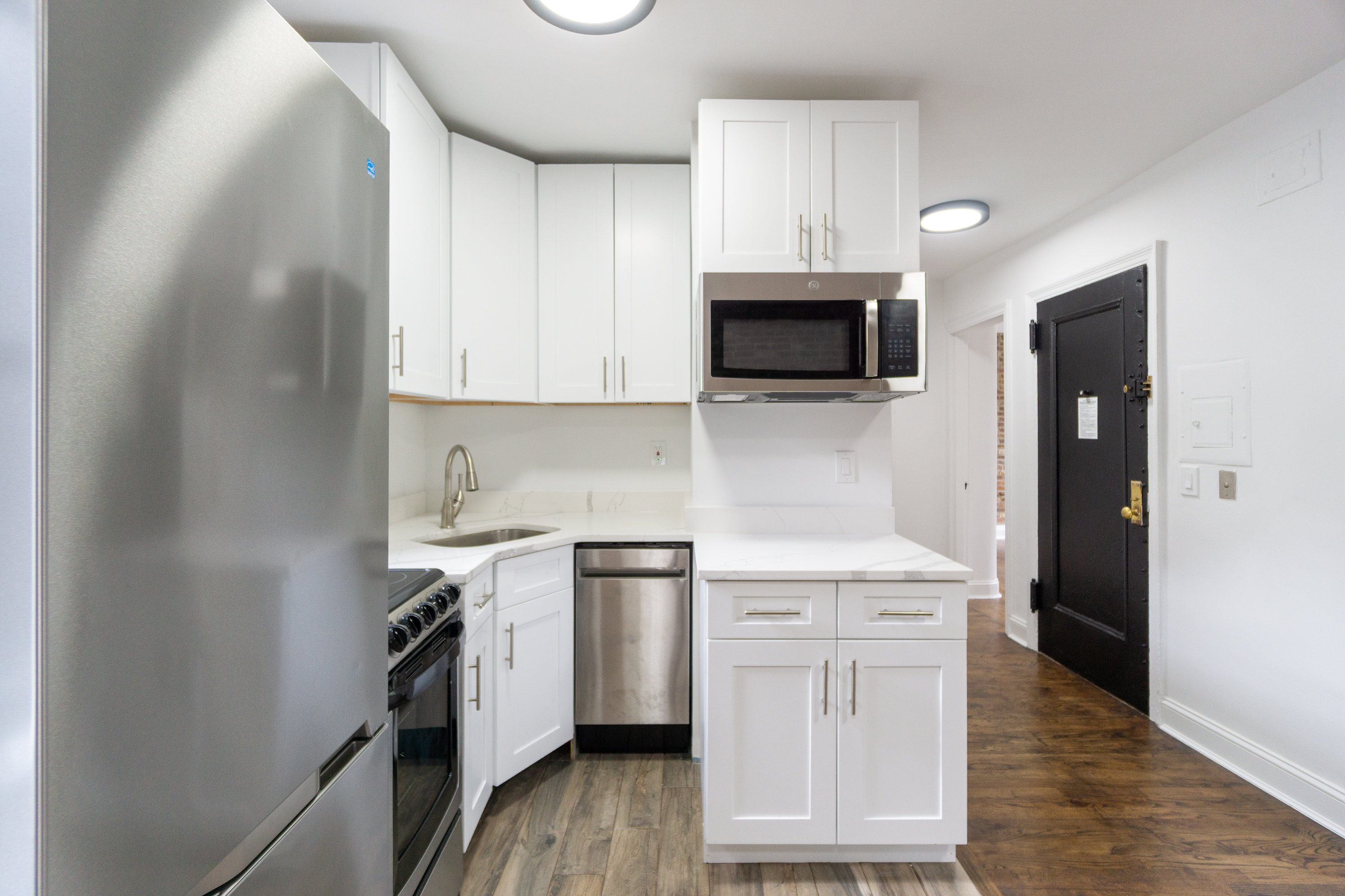 342 East 6th Street, Unit 3 Manhattan, NY 10003 - Photo 4 of 13 a kitchen with stainless steel appliances a stove sink microwave and cabinets