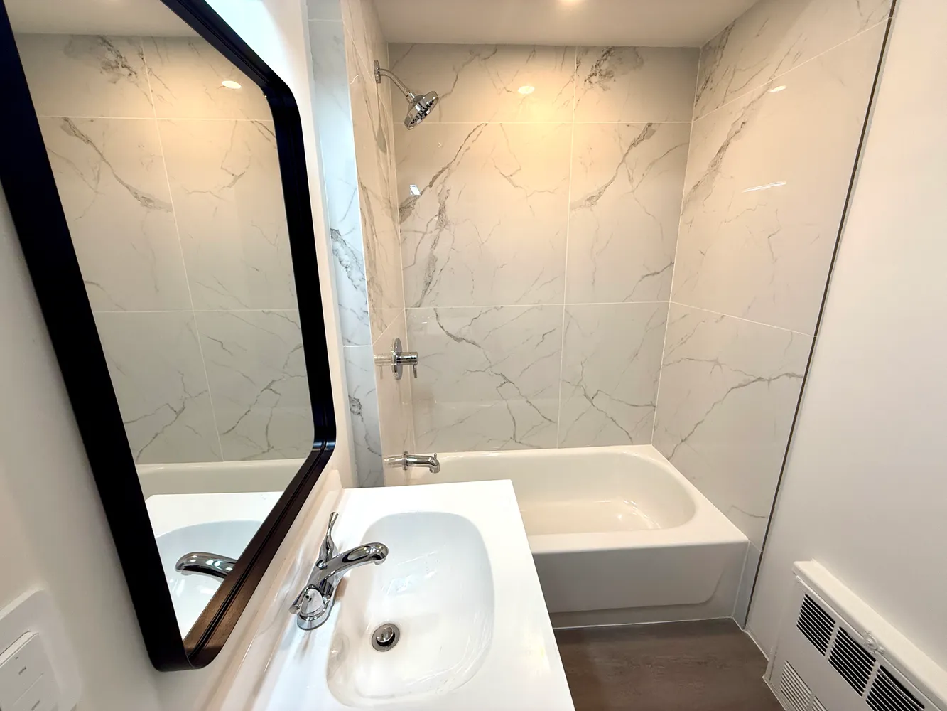 a bathroom with a tub a sink and a shower