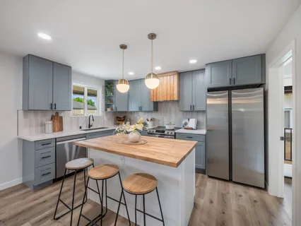 a kitchen with granite countertop a sink a center island and stainless steel appliances