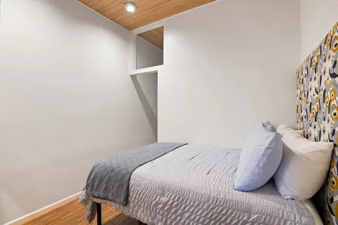 a bedroom with a bed and a potted plant