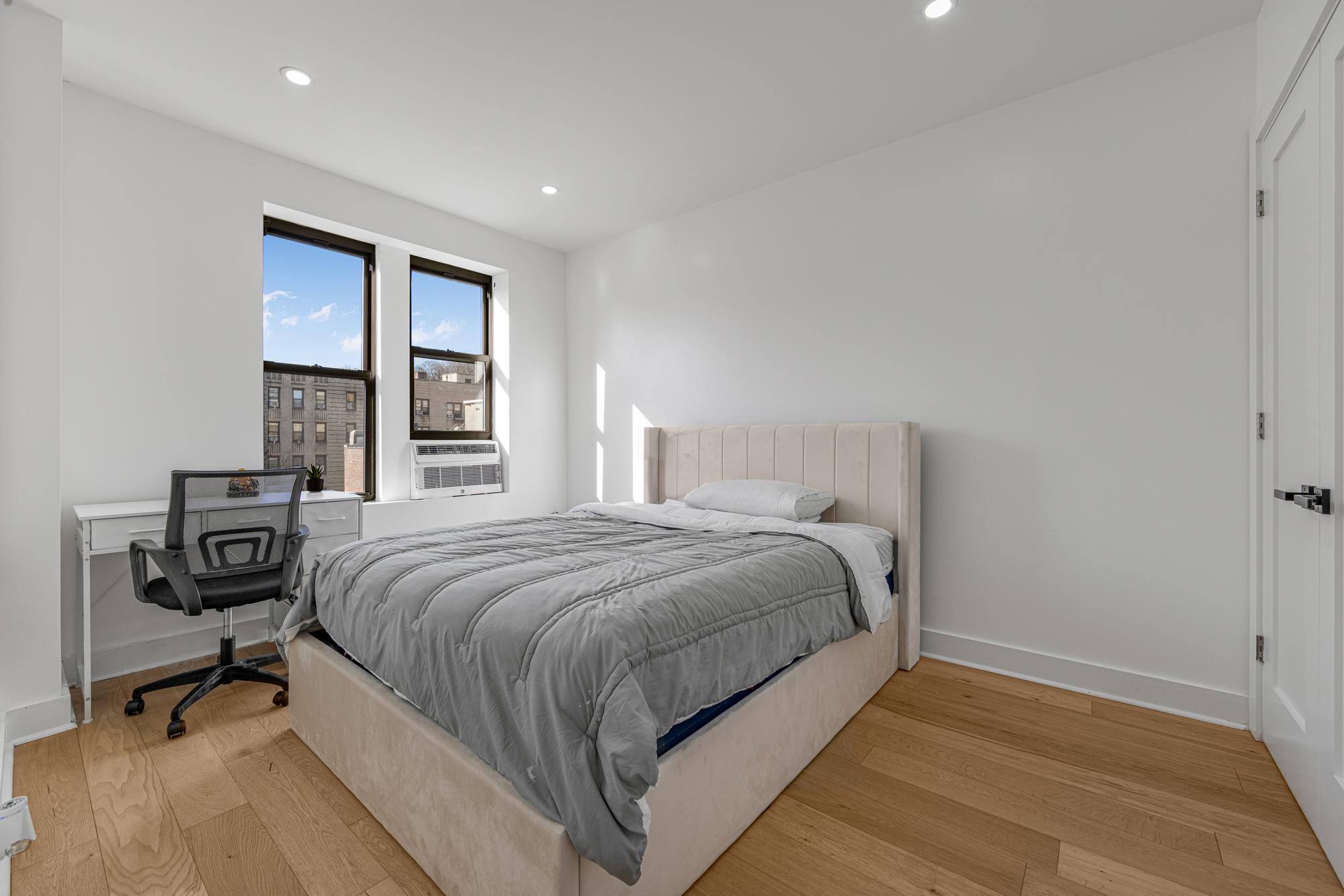 78 Thayer Street, Unit E5 Manhattan, NY 10040 - Photo 6 of 8 a bedroom with a bed and a window