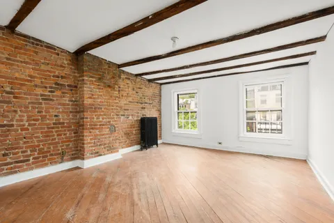 a view of an empty room with a window and a fireplace