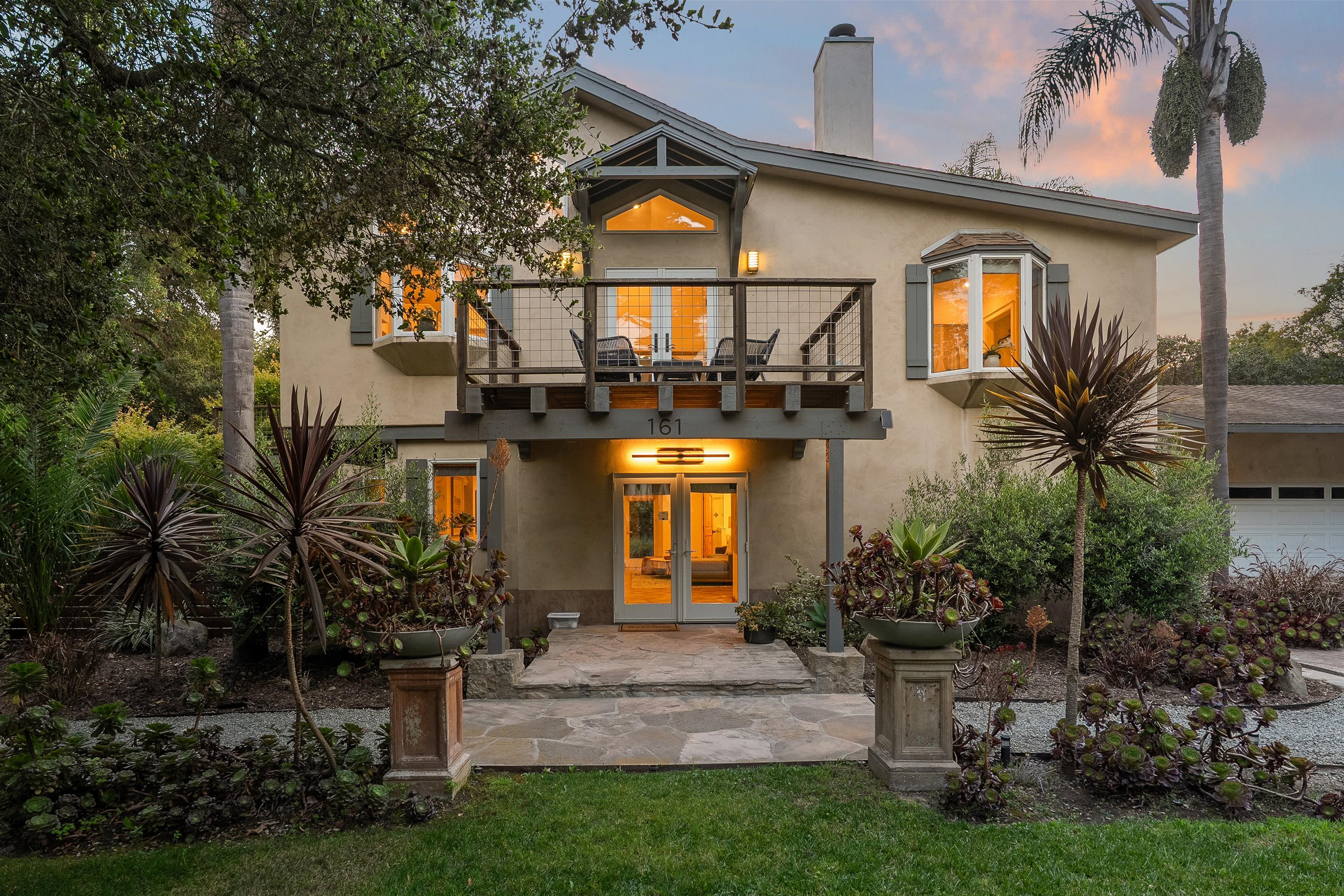 a front view of a house with a garden