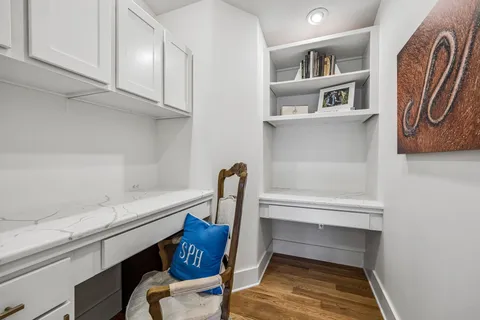 a kitchen with cabinets a sink appliances and chairs