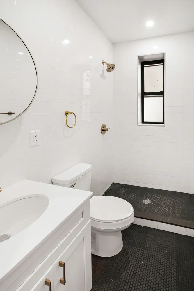a bathroom with a sink a toilet and a mirror