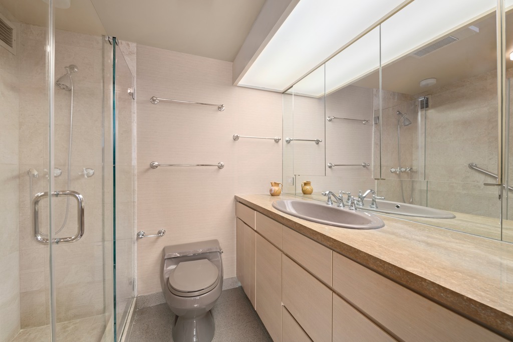 25 Sutton Place South, Unit 18M Manhattan, NY 10022 - Photo 7 of 11 a bathroom with a granite countertop sink a toilet and shower