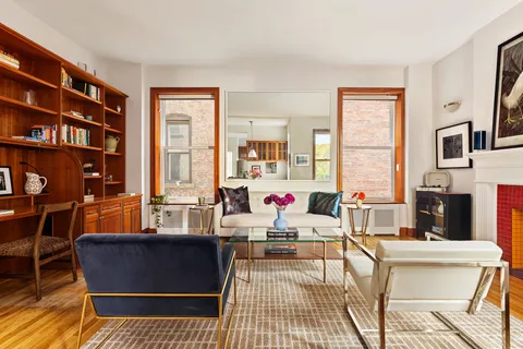 a living room with fireplace furniture and a floor to ceiling window