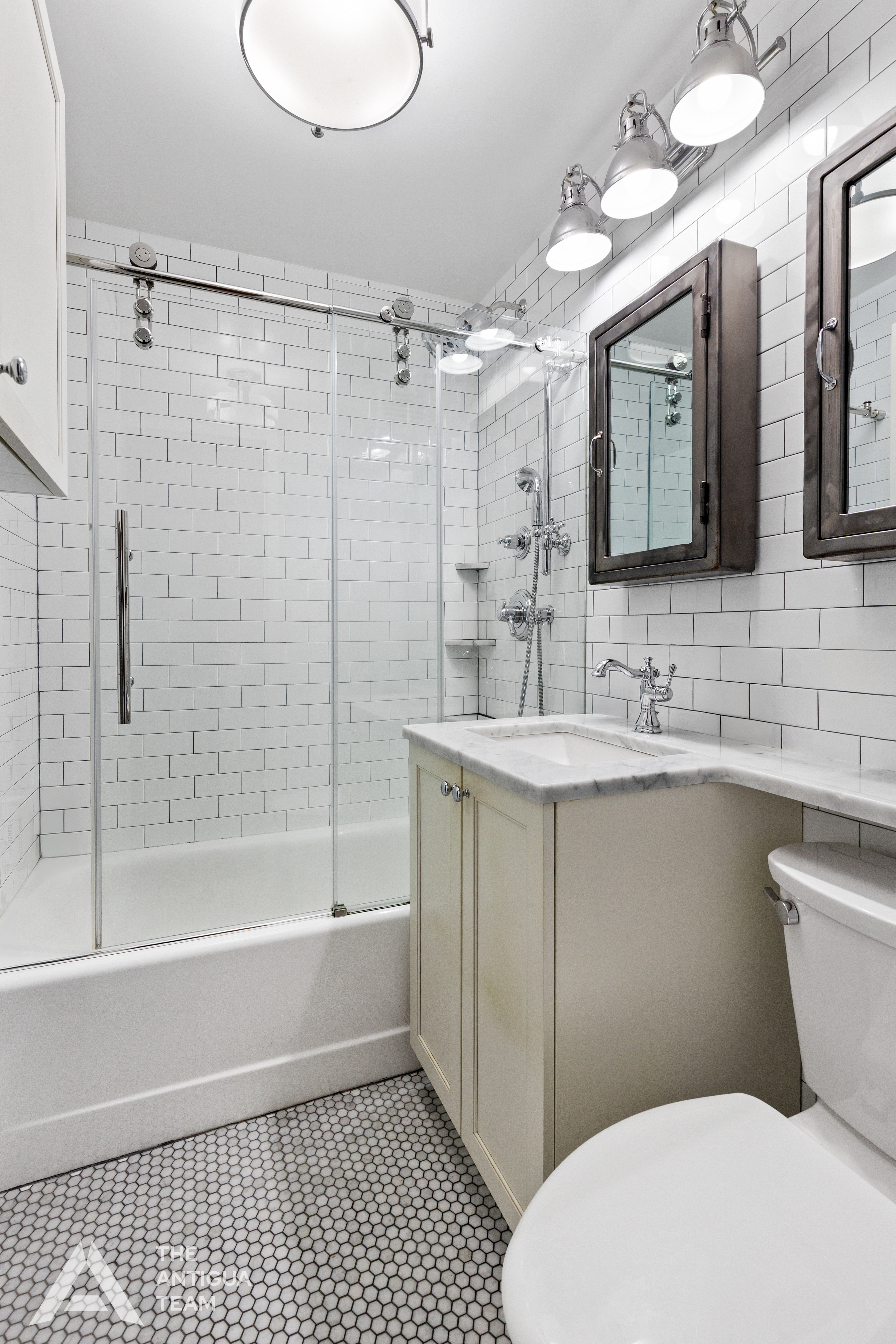 152 East 35th Street, Unit 3A Manhattan, NY 10016 - Photo 9 of 13 a bathroom with a sink a toilet a mirror and shower
