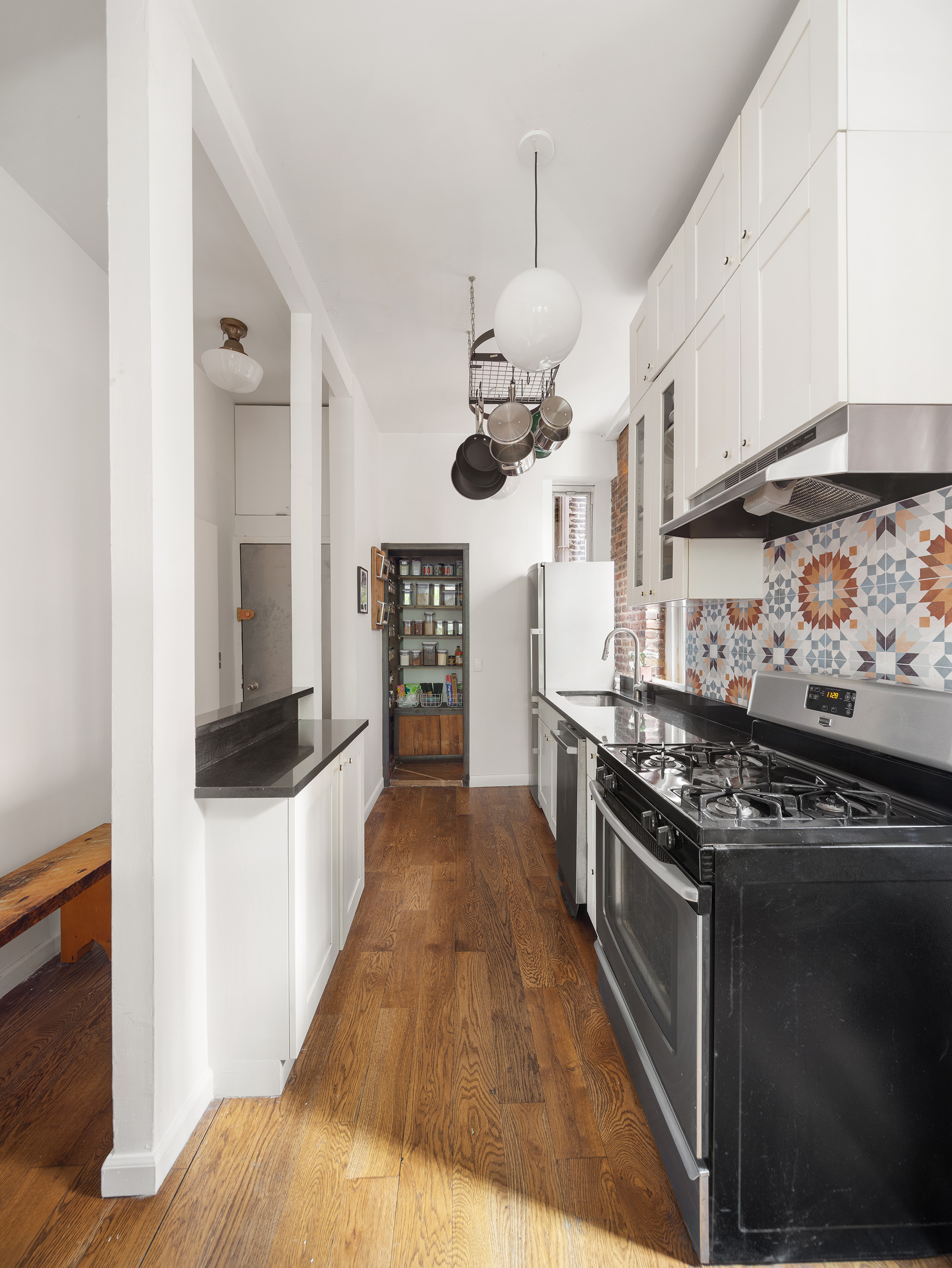 71 East 3rd Street, Unit 4 Manhattan, NY 10003 - Photo 6 of 18 a kitchen with stainless steel appliances granite countertop a stove and a refrigerator
