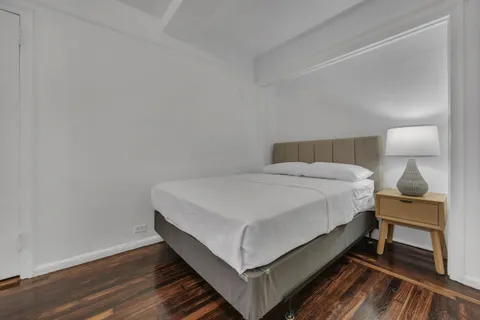a bedroom with a bed and wooden floor
