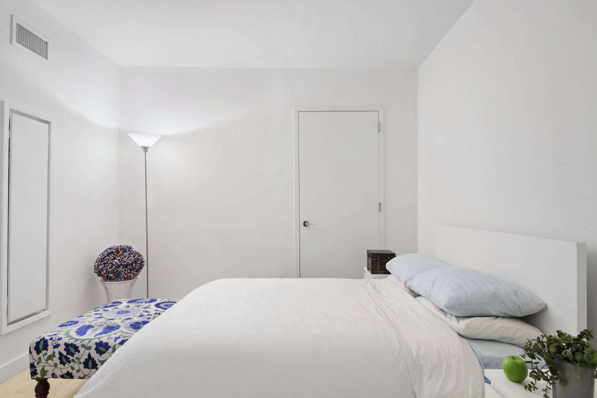 15 Broad Street, Unit 2506 Manhattan, NY 10005 - Photo 6 of 23 a bedroom with a bed and a potted plant