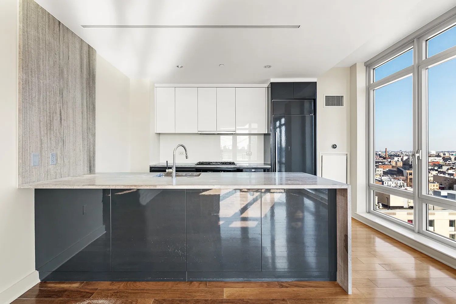 a view of a kitchen with granite countertop a refrigerator and cabinets