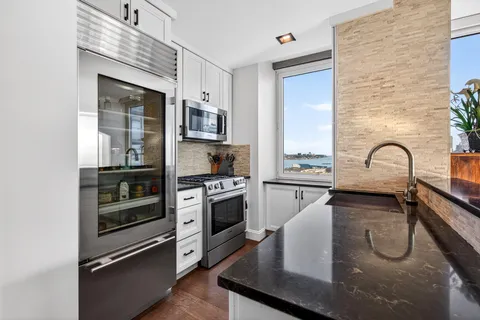 a kitchen with a sink stainless steel appliances and cabinets