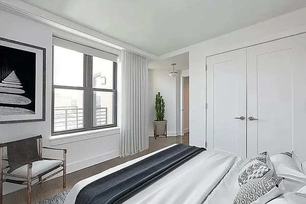 341 Eastern Parkway, Unit 5E Brooklyn, NY 11216 - Photo 3 of 8 a bedroom with a bed and a window with chair