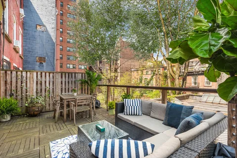 a balcony with wooden floor table and chairs