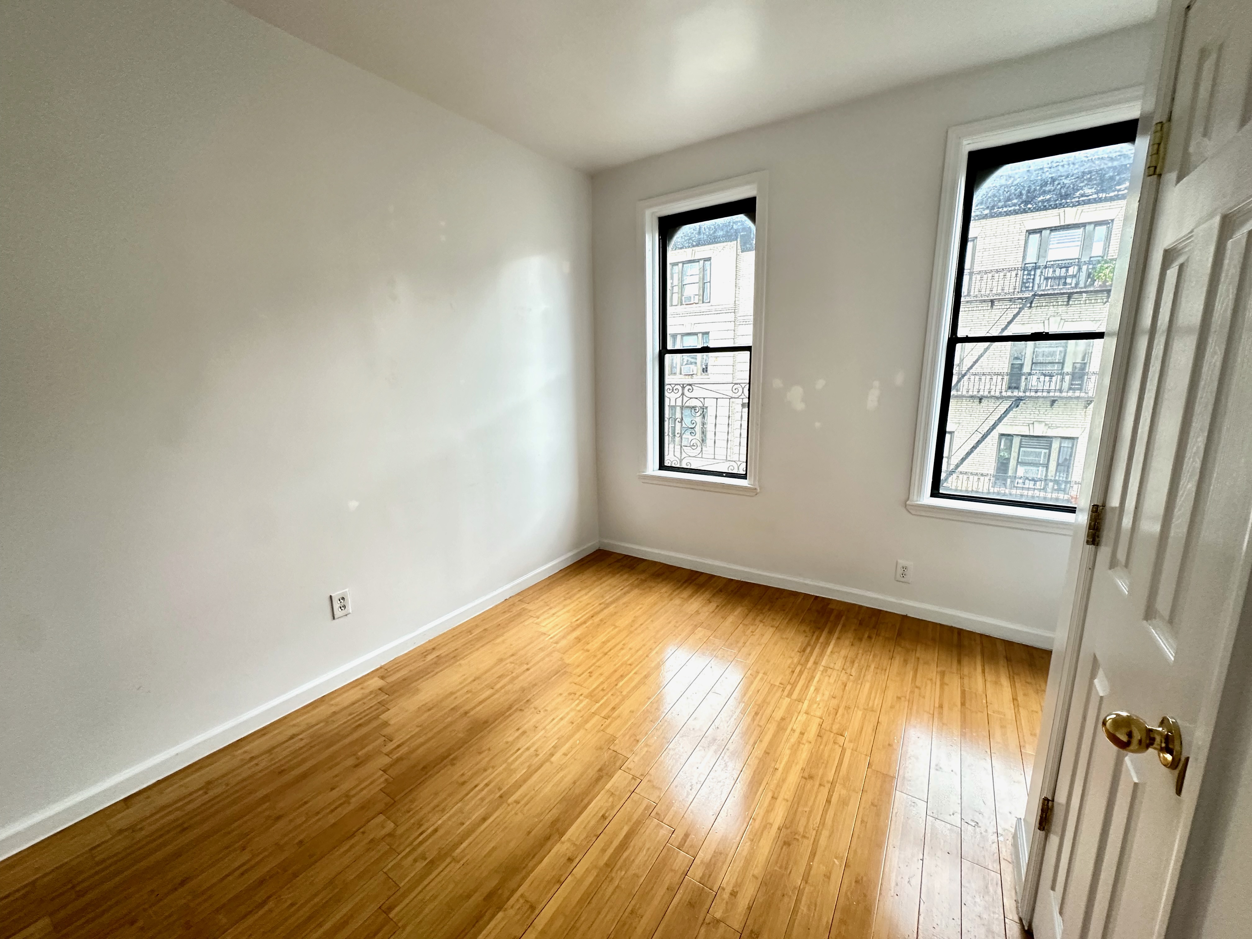 541 West 144th Street, Unit 17 Manhattan, NY 10031 - Photo 6 of 6 an empty room with wooden floor and windows