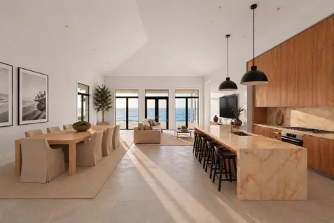 a large kitchen with kitchen island a stove a sink a dining table and chairs